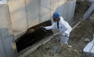 Professional waterproofing the exterior walls of the basement in Spokane, WA